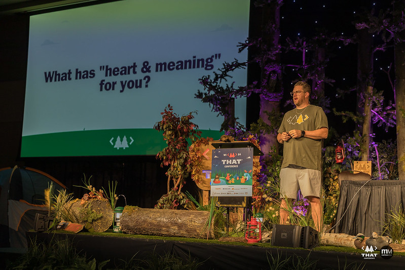 Clark Sell on stage at THAT Conference in front of a slide that reads: What has heart and meaning for you?